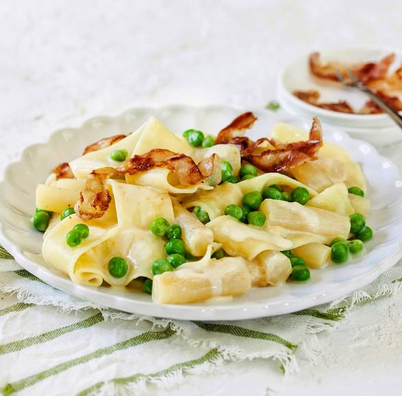 Pappardelle mit Schwarzwurzel-Rahm, Erbsen und krossem Pancetta angerichtet auf einem Teller