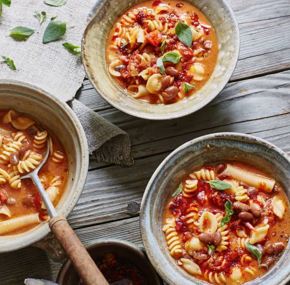 Nudeln mit Bohnen in drei Schüsseln auf einem Tisch