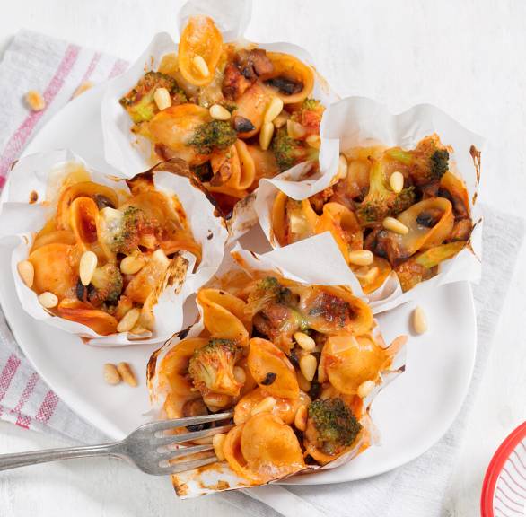 Vier Nudelmuffins mit Pilzen und Brokkoli auf einem Teller