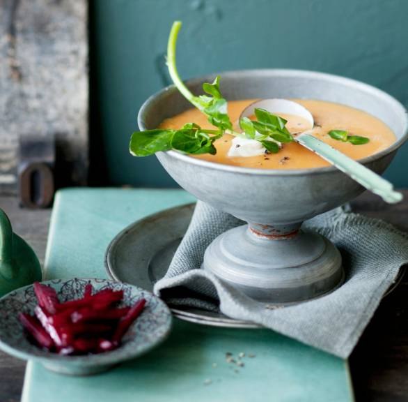 Pastinakensuppe in einer Schüssel, daneben eingelegte Rote Bete auf einem Teller