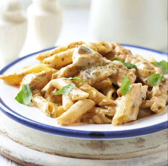 Penne Käsesoße und Putenschnitzelstreifen auf einem Teller