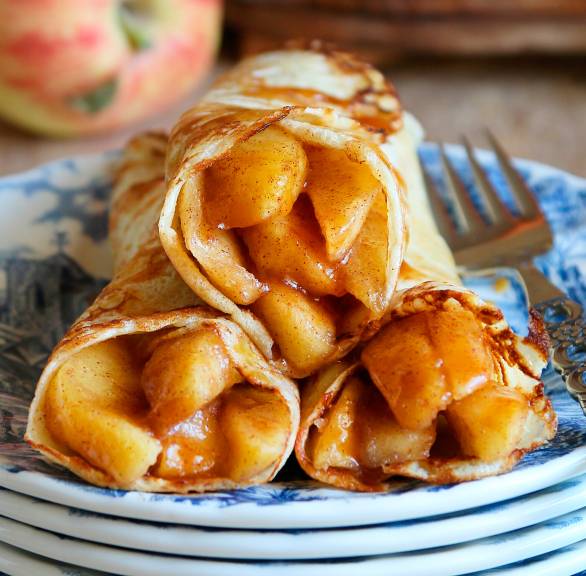 Pfannkuchen mit Apfel-Karamell-Füllung gerollt auf einem Teller
