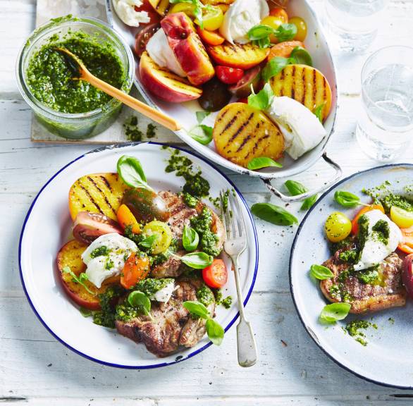 Caprese-Salat mit Pfirsichen und Lammkoteletts vom Grill auf einem Teller