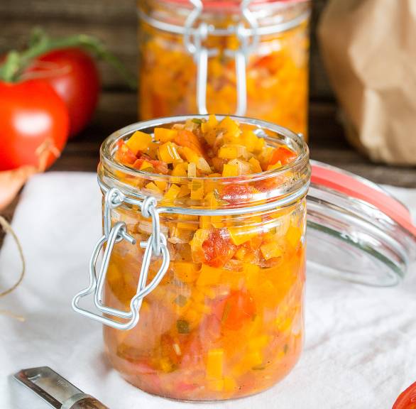 Selbstgekochtes Karotten-Tomaten-Chutney in mehreren Einmachgläsern auf einem Tisch