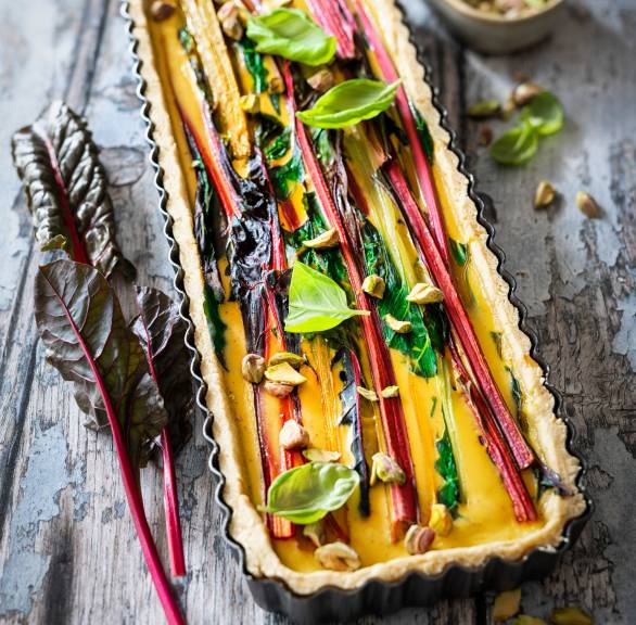 Mangoldquiche in einer rechteckigen Backform getoppt mit Pistazien