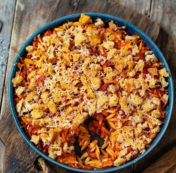Reisnudelauflauf mit Salsiccia überbacken mit Käsekrümeln auf einem Tisch