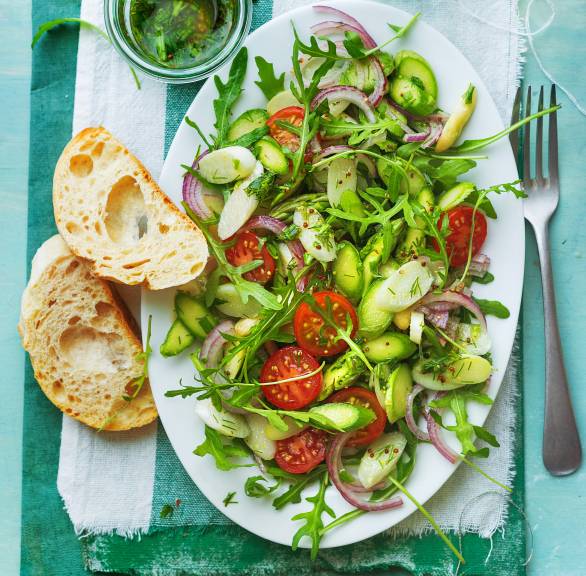 Spargelsalat aus rohem weißem und grünem Spargel auf einem ovalen Teller