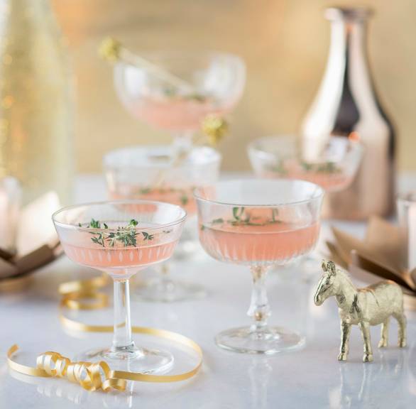 Rosa Weihnachtspunsch in mehrere Sektschalen auf einem festlich dekorierten Tisch