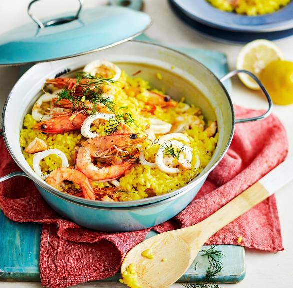 Safranrisotto mit Meeresfrüchten in einem Kochtopf auf einem Tisch