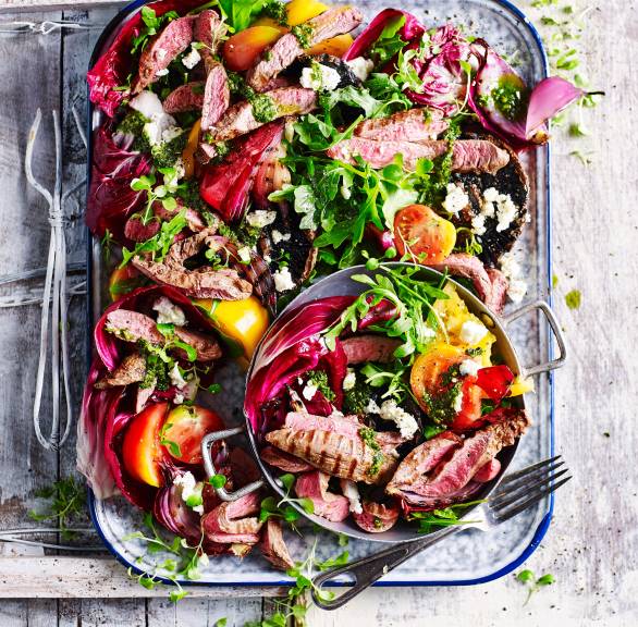 Salat mit Spinatpesto-Dressing getoppt mit Lamm vom Grill in einer rechteckigen Form auf einem Tisch