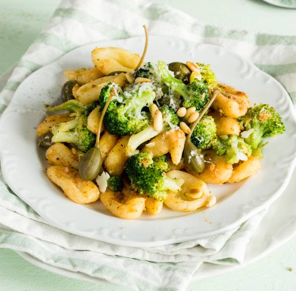 Brokkoli-Nudeln auf einem tiefen Teller mit Sardellen und Kapernäpfeln getoppt