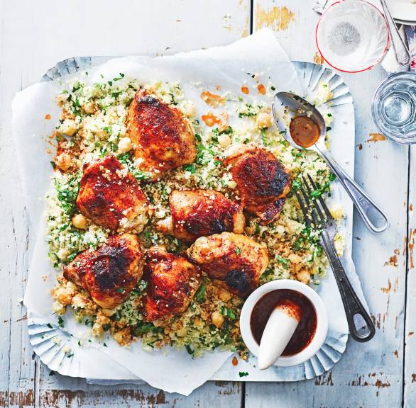 Im Ofen gebackene, marinierte Hähnchenkeulen auf einem Mix aus Couscous und Kichererbsen