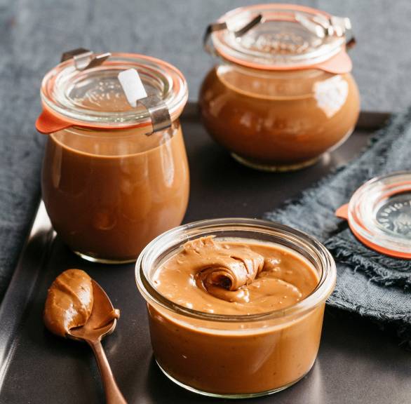 Selbstgemachter Haselnuss-Schoko-Aufstrich in mehreren Weckgläsern auf einem Tisch