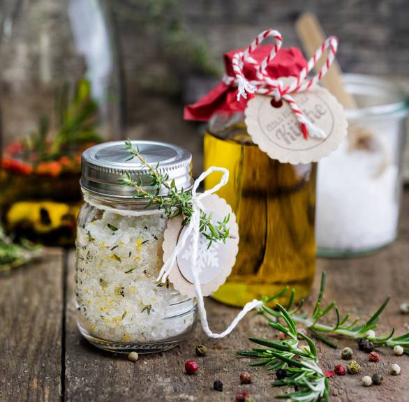 Selbstgemachtes Gewürzset aus italienischem Gewürzöl und Gewürzsalz in weihnachtlich verpackten Gläsern