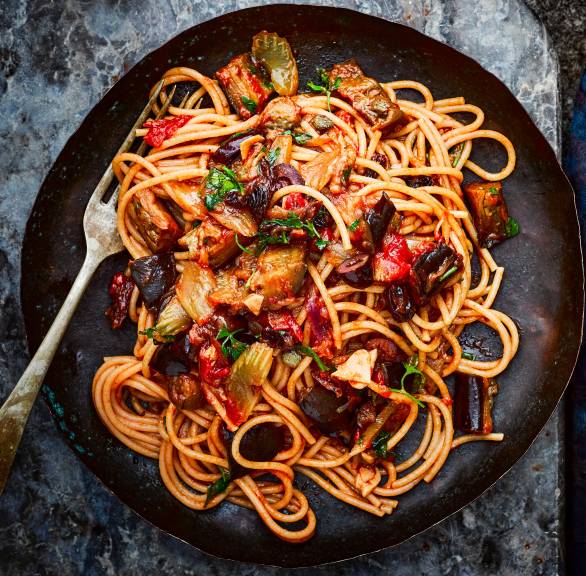 Spaghetti mit sizilianischer Caponata aus Auberginen und anderen Gemüsesorten angerichtet auf einem Pastateller