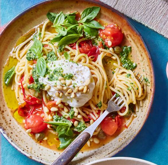 Spaghetti angerichtet auf mehreren Pastatellern getoppt von  Tomaten, Burrata und Basilikum-Minz-Pesto