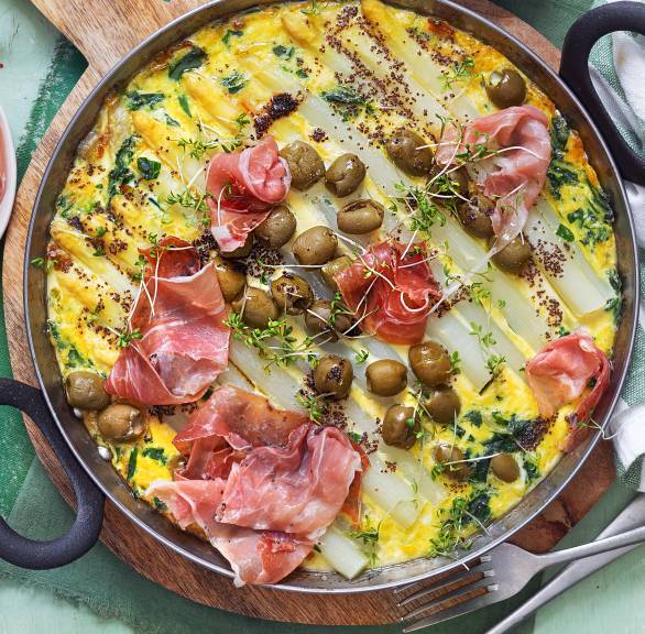 Frittata di Asparagi Spargelfrittata von oben in einer ofenfesten Pfanne getoppt mit Schinken und Oliven