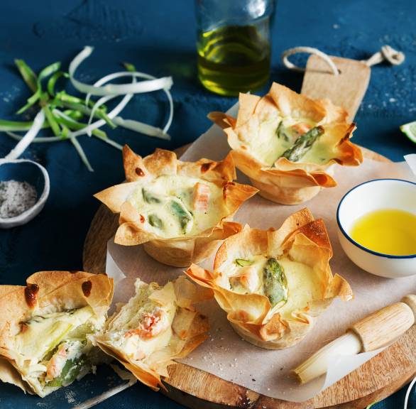 Spargelmuffins aus Filoteig mit Lachs auf einem Holzbrett