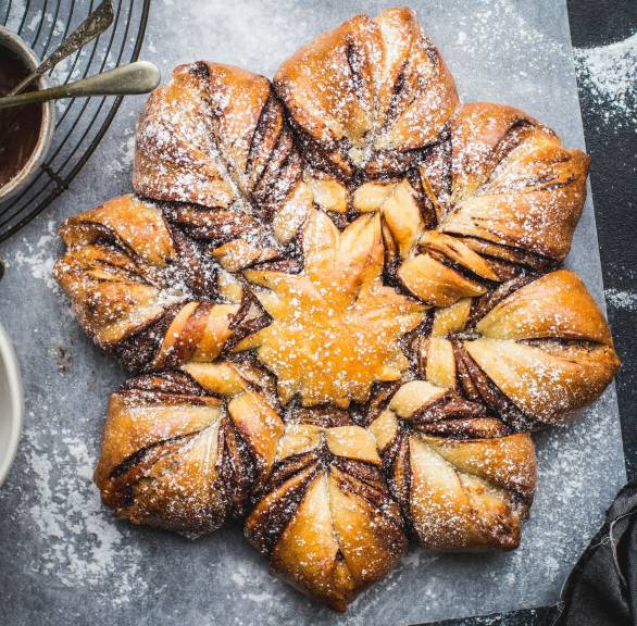Selbstgebackener Weihnachtsstern mit Schokofüllung zum Zupfen auf einerm Stück Babckpapier