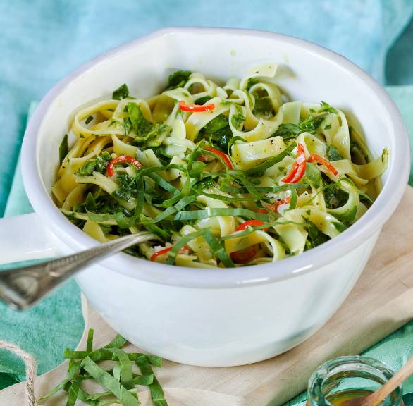 Bärlauchnudeln in einem Topf getoppt mit frischem Bärlauch, Peperoncino-Streifen und Parmesan