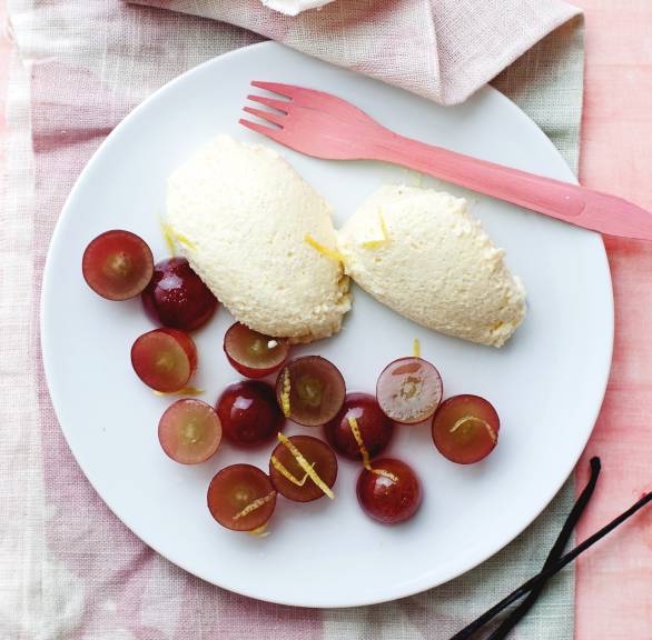 Zwei Nocken Vanillemousse angerichtet mit Traubensalat auf einem Dessertteller