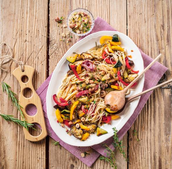 Veganer Nudelsalat mit Antipasti auf einem ovalen Teller