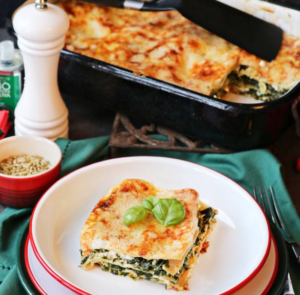 Vollkorn-Spinatlasagne mit Feta in einer Auflaufform auf einem Tisch