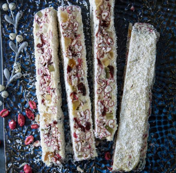 Streifen selbst gemachter, weißer Weihnachtsschokolade auf einem schwarzen Teller