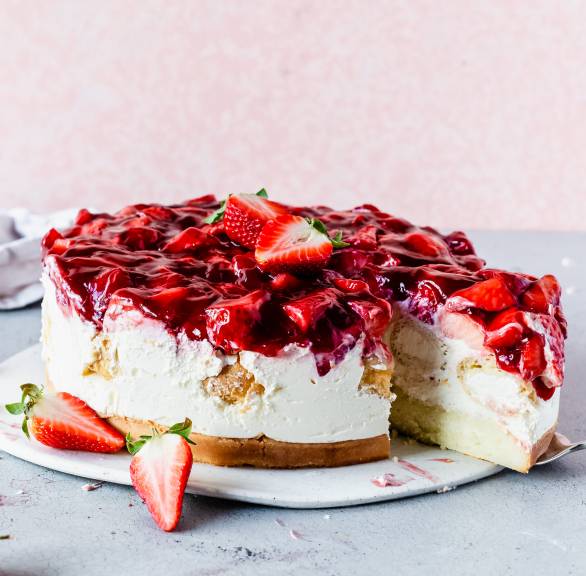 Erdbeer-Windbeutel-Torte angeschnitten auf einer Tortenplatte