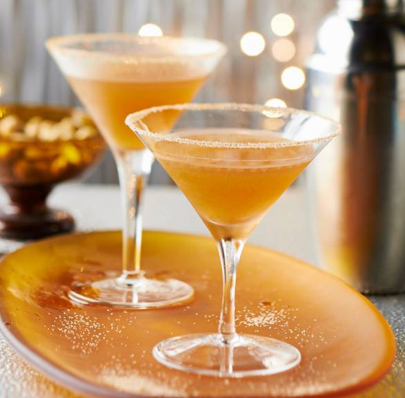 Zwei Martinis auf einem festlich dekorierten Tisch neben einem Cocktailshaker