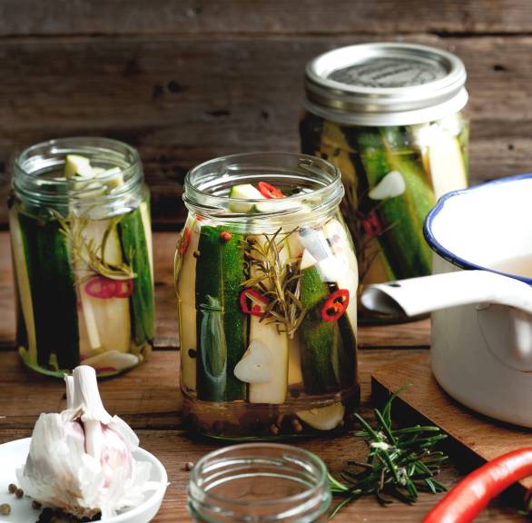 Zucchini eingelegt und in Schraubgläser gefüllt auf einem Tisch