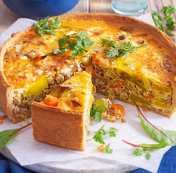 Dinkel-Grünkern-Quiche angeschnitten auf einem Tisch