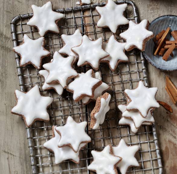 Selbst gebackene Zimtsterne mit Glasur auf einem Kuchengitter