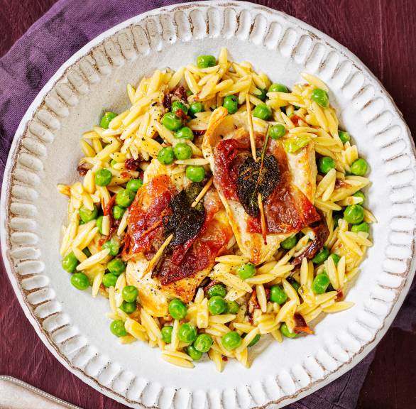Risoni-Pastasotto mit Hähnchen-Saltimbocca angerichtet auf einem Pastateller