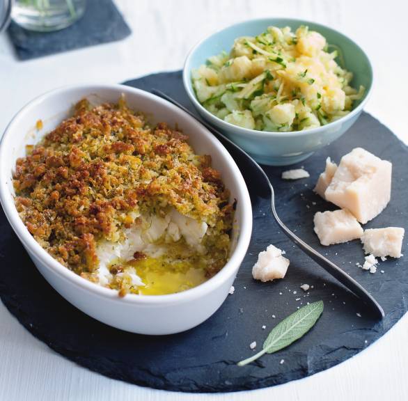 Kabeljau mit Kräuter-Parmesan-Kruste in einer Auflaufform, daneben eine Schale mit Zucchini-Stampfkartoffeln und Parmesan