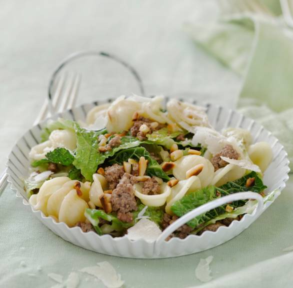 Pfanne mit Wirsing, Hackfleisch und Orechiette getoppt von Parmesan und Pinienkernen auf einem Tisch