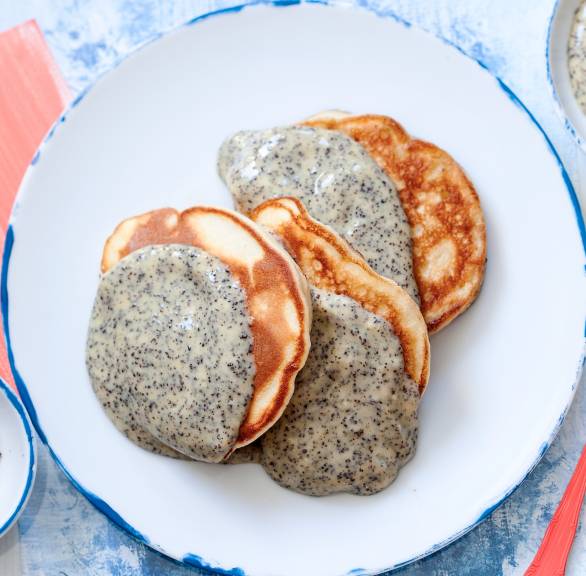 Ricotta-Apfel-Pfannkuchen auf einem Teller getoppt mit Mohnsoße