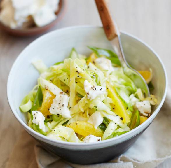 Spitzkohlsalat mit Orangenstücken und Gorgonzola in einer Schüssel