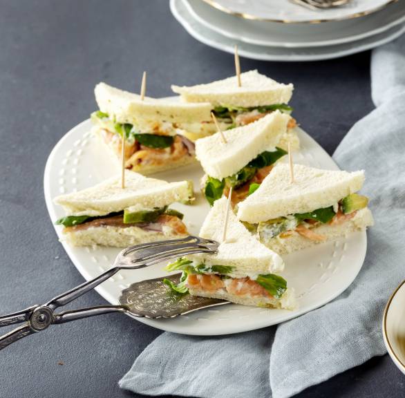 Eine Platte mit Tramezzini mit Lachs, Avocado und Kapern