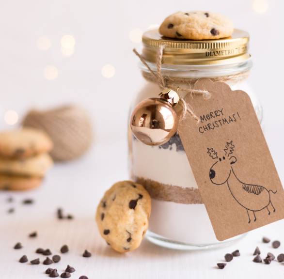 Backmischung im Glas für Schoko-Nuss-Kekse dekoriert mit fertigen Keksen und einem Geschenkanhänger