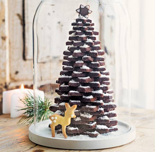 Biscotti di Natale als Tannenbaum angerichtet unter einer Glaskuppel, daneben Weihnachtsdeko