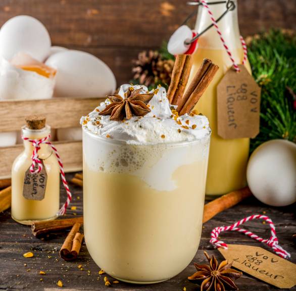 Bombardino in einem Glas, daneben eine Flasche abgefüllt mit geschenkband versehen