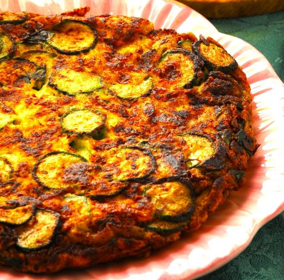 Frittata di Zucchine auf einem Teller, daneben Olivenöl in einer Karaffe