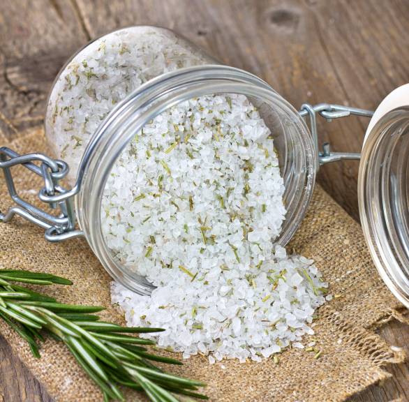 Selbst gemachtes italienisches Gewürzsalz in einem Weckglas, daneben frische Kräuter