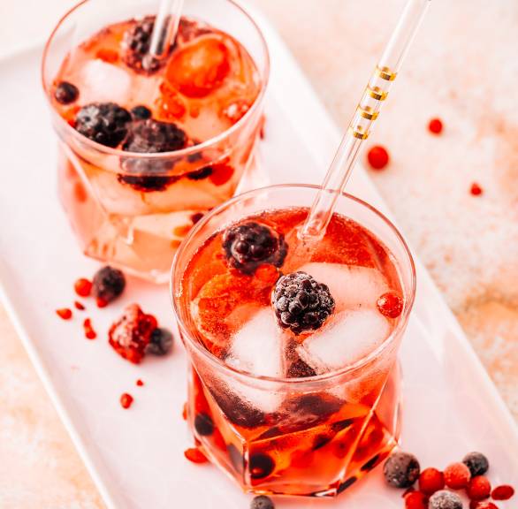 Lillet-Bowle in zwei Gläsern auf einem Tablett dekoriert mit frischen Beeren