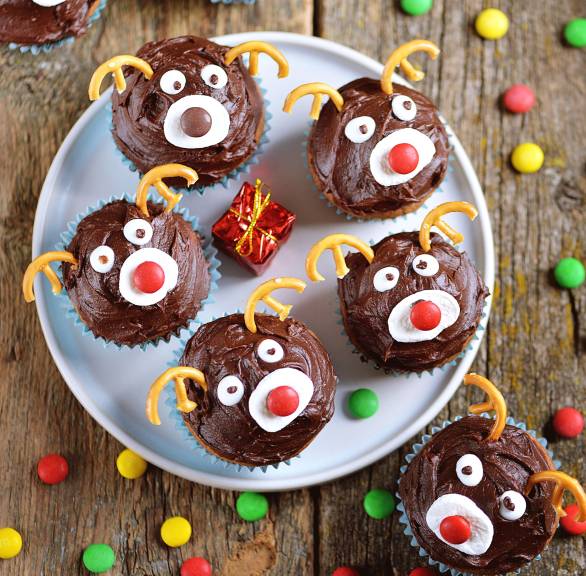 Rentiermuffins auf einer Kuchenplatte auf einem weihnachtlich dekorierten Tisch