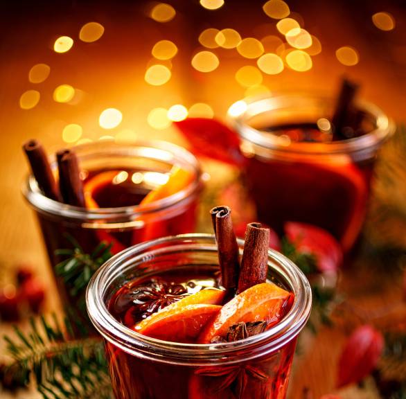 Vin Brulé: Italienischer Glühwein in drei Gläsern auf einem weihnachtlich dekorierten Tisch