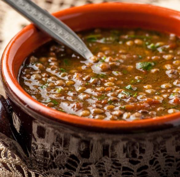 Zuppa di lenticchie nel coccio in einem Tontopf auf einem Tisch