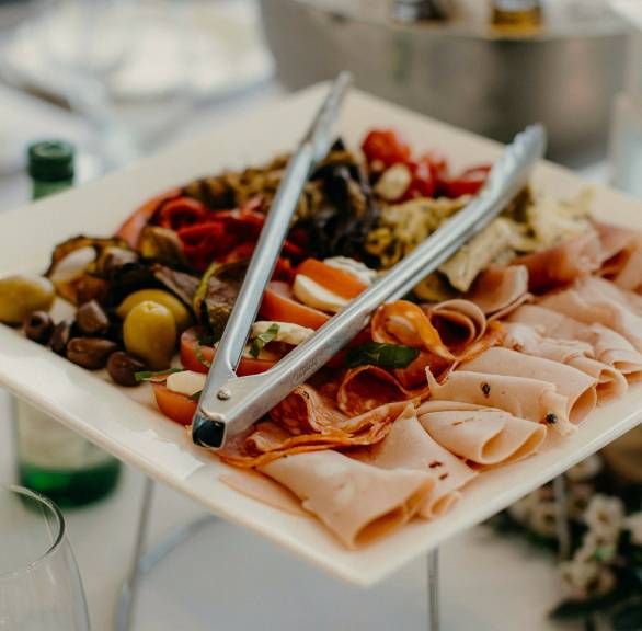 Quadratische Platte mit gemischten italienischen Antipasti auf einem festlich gedeckten Tisch