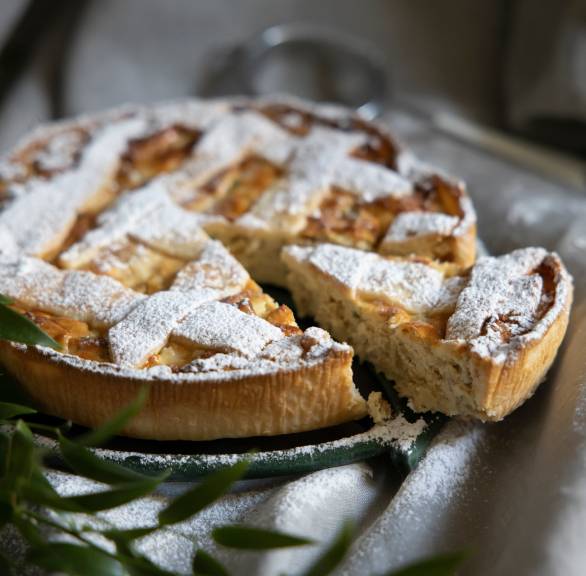 Neapolitanische Torte mit Gittermuster angeschnitten auf einer Kuchenplatte